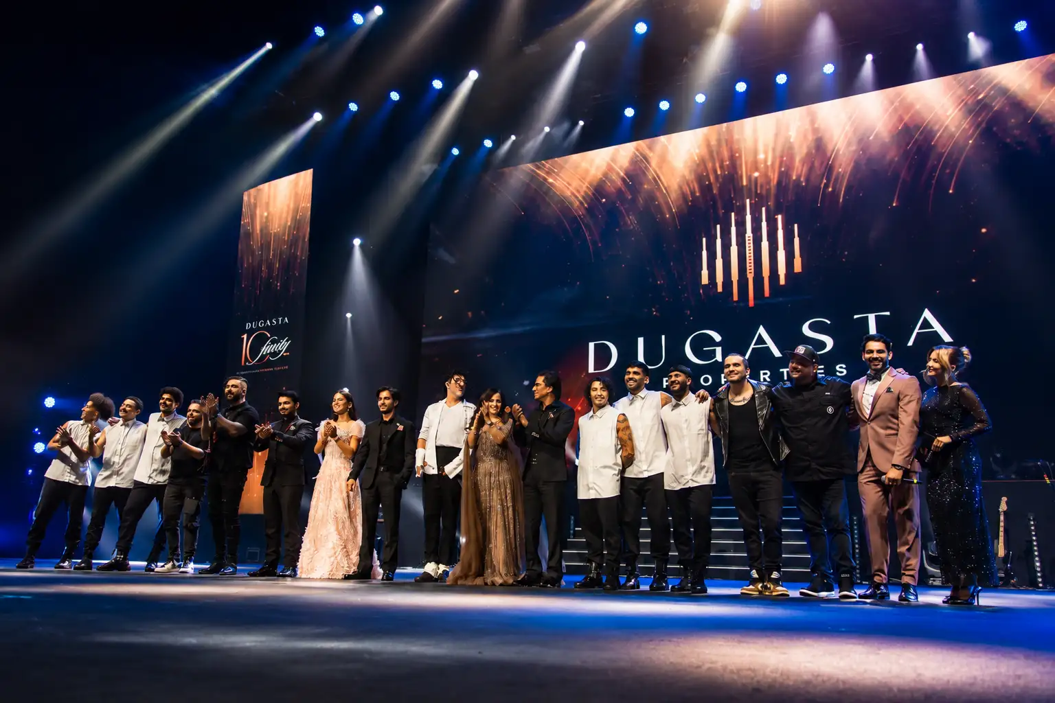 Performers, musicians and professional MCs celebrating together on stage at a Dugasta Properties corporate event in Dubai.