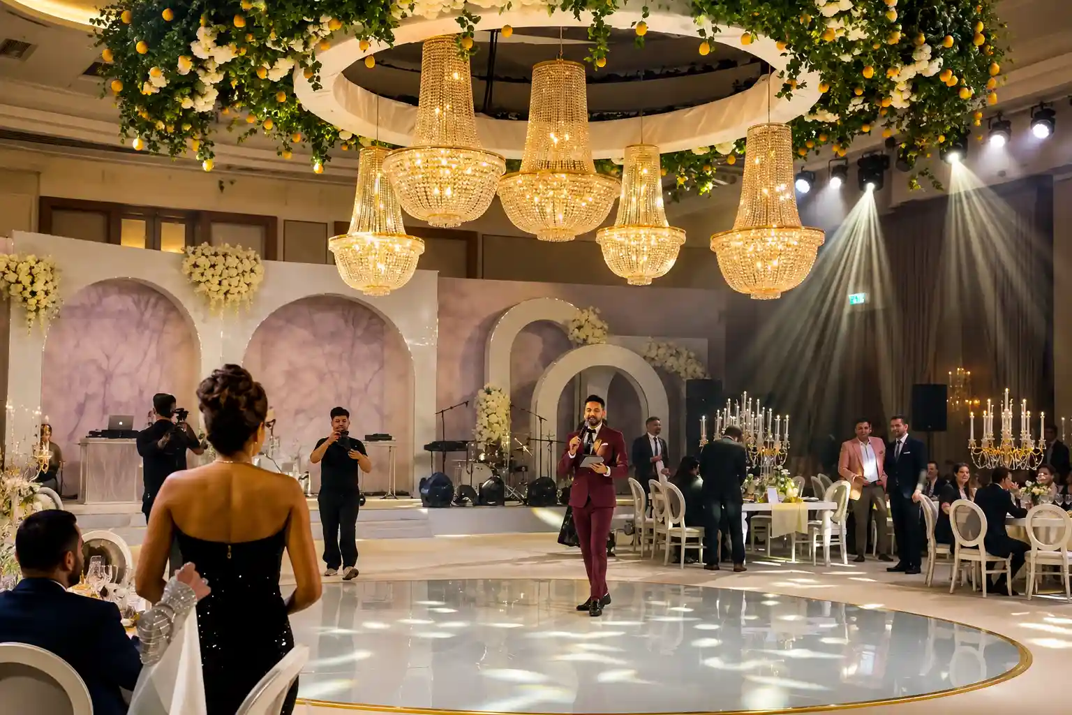 Darryl Rees hosting Punir and Marina’s Dubai wedding reception as their Wedding MC, surrounded by elegant chandeliers, floral decor and guests.
